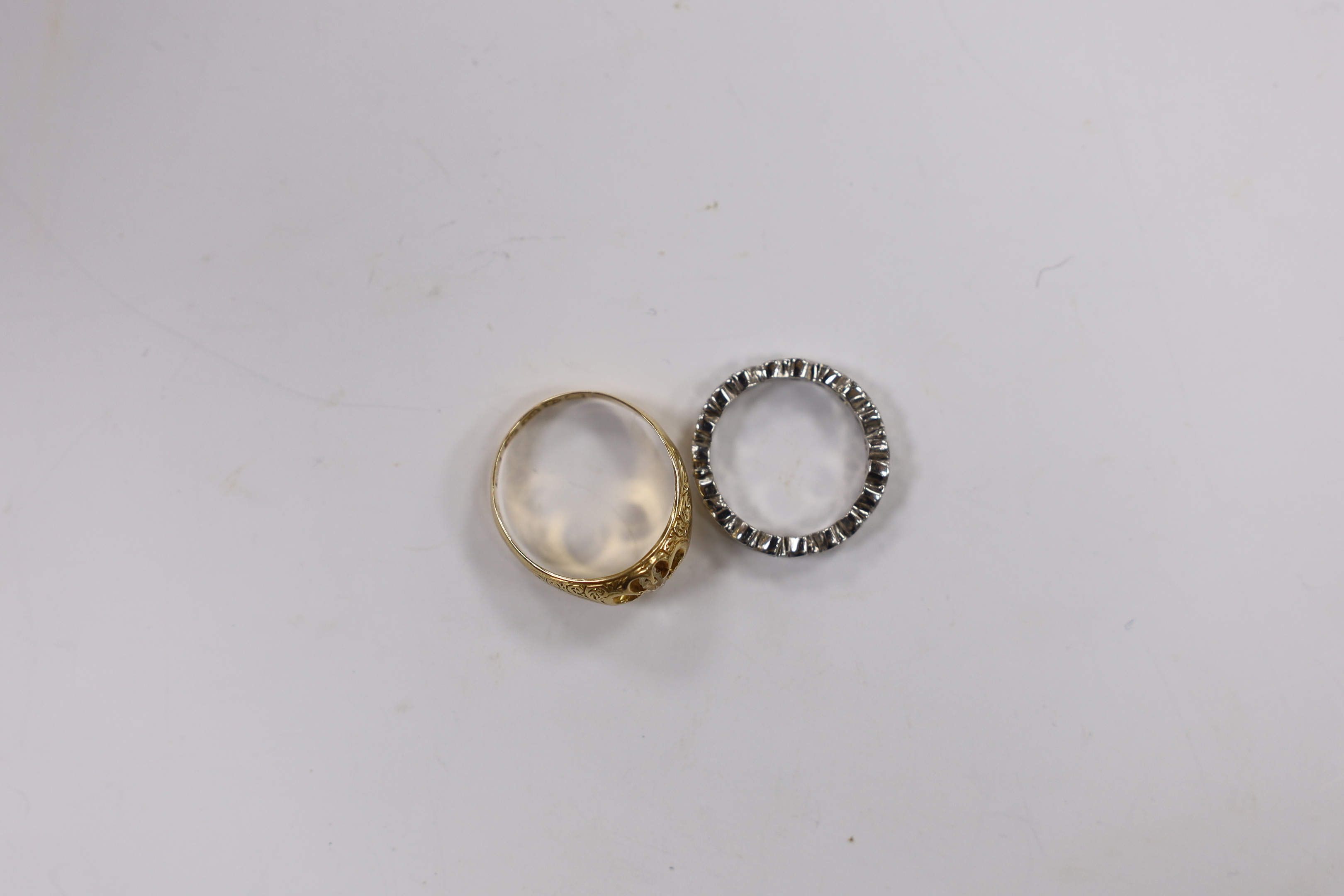 An early 20th century 18ct gold and claw set solitaire diamond ring, size M, gross 3.8 grams and a modern platinum and diamond chip set full eternity ring, size G, gross 3.1 grams.